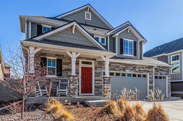 4104 N Picadilly Ct, Aurora, CO 80019 - craftsman-style home featuring covered porch, driveway, an attached garage, stone siding, and roof with shingles