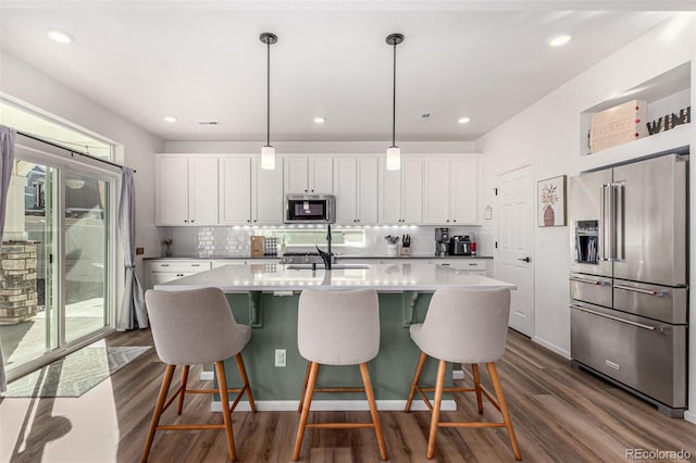 4104 N Picadilly Ct, Aurora, CO 80019 - kitchen with stainless steel appliances, dark wood-style flooring, white cabinetry, backsplash, and recessed lighting