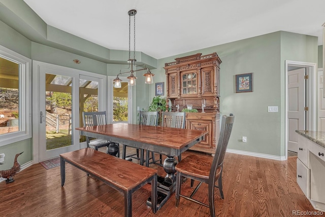 dining space featuring light wood-type flooring and baseboards