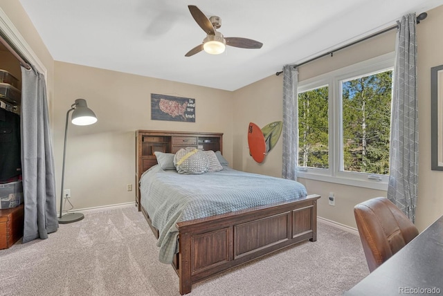 bedroom with a ceiling fan, light colored carpet, and baseboards