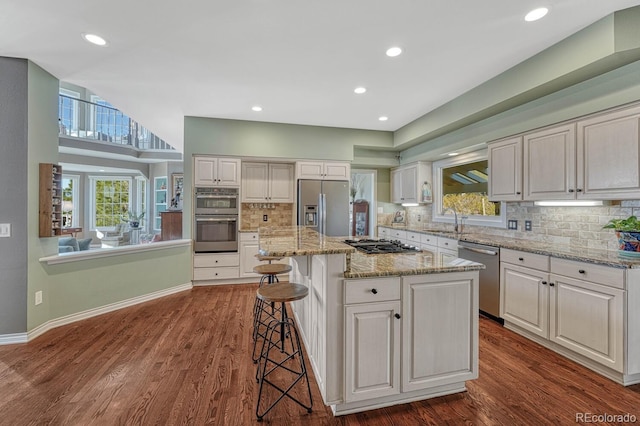 kitchen with appliances with stainless steel finishes, dark wood-type flooring, a sink, and white cabinetry