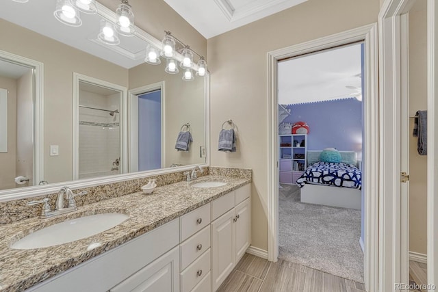 full bath with a shower, double vanity, and a sink