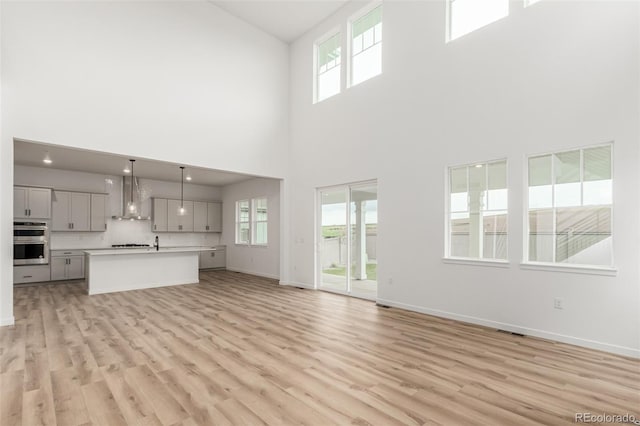 1826 Hickory Ave, Erie, CO 80516 - unfurnished living room with a towering ceiling and light wood-type flooring