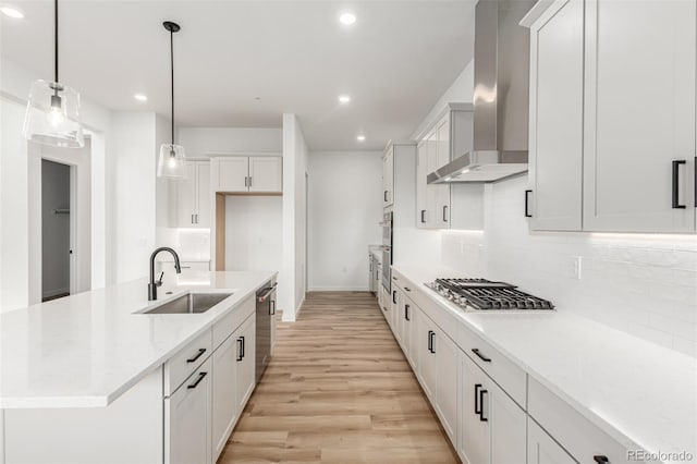 1826 Hickory Ave, Erie, CO 80516 - kitchen featuring wall chimney exhaust hood, stainless steel appliances, recessed lighting, light wood finished floors, and backsplash