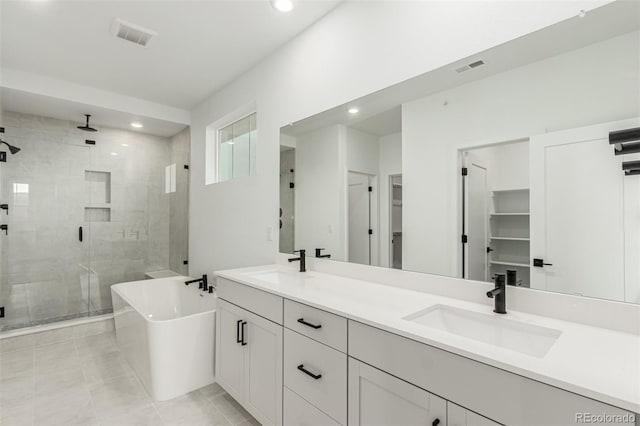 1826 Hickory Ave, Erie, CO 80516 - bathroom featuring a stall shower, double vanity, a freestanding tub, recessed lighting, and tile patterned flooring