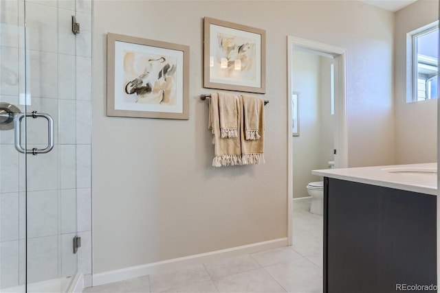 bathroom featuring tile patterned flooring, vanity, a shower with door, and toilet