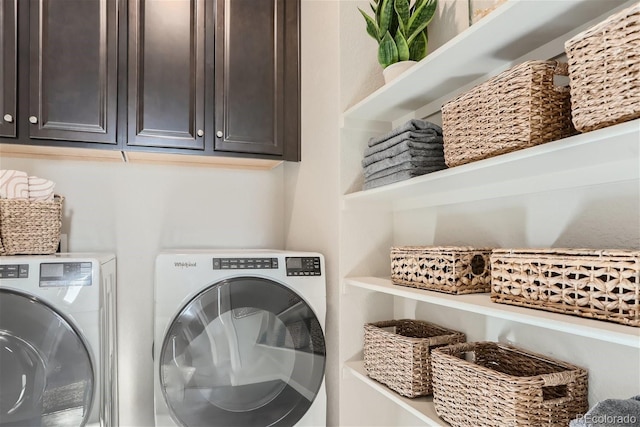 laundry room featuring separate washer and dryer and cabinets