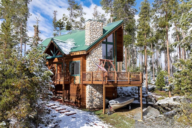 507 Gcr 4980, Grand Lake, CO 80447 - back of property with stone siding, a deck, metal roof, and a chimney