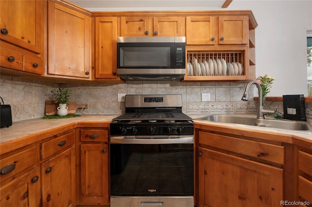 507 Gcr 4980, Grand Lake, CO 80447 - kitchen with stainless steel appliances, a sink, tile counters, brown cabinetry, and decorative backsplash