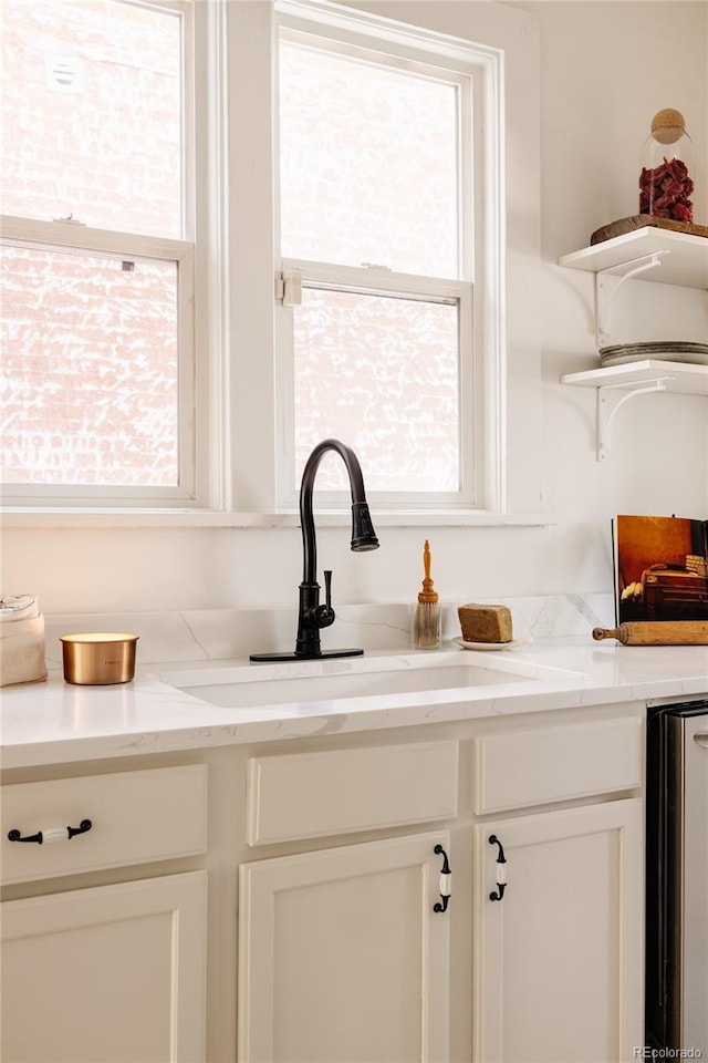 321 Fox St, Denver, CO 80223 - kitchen featuring open shelves, a sink, plenty of natural light, and white cabinets