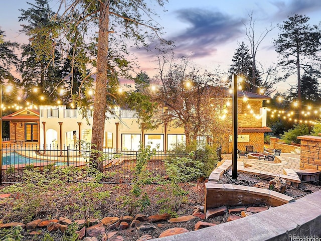 back of house with a fire pit, a patio, fence, and stucco siding