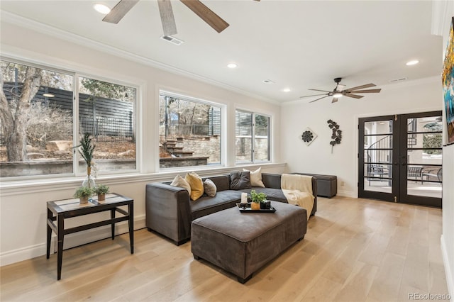 living room featuring ornamental molding, visible vents, and light wood-style flooring