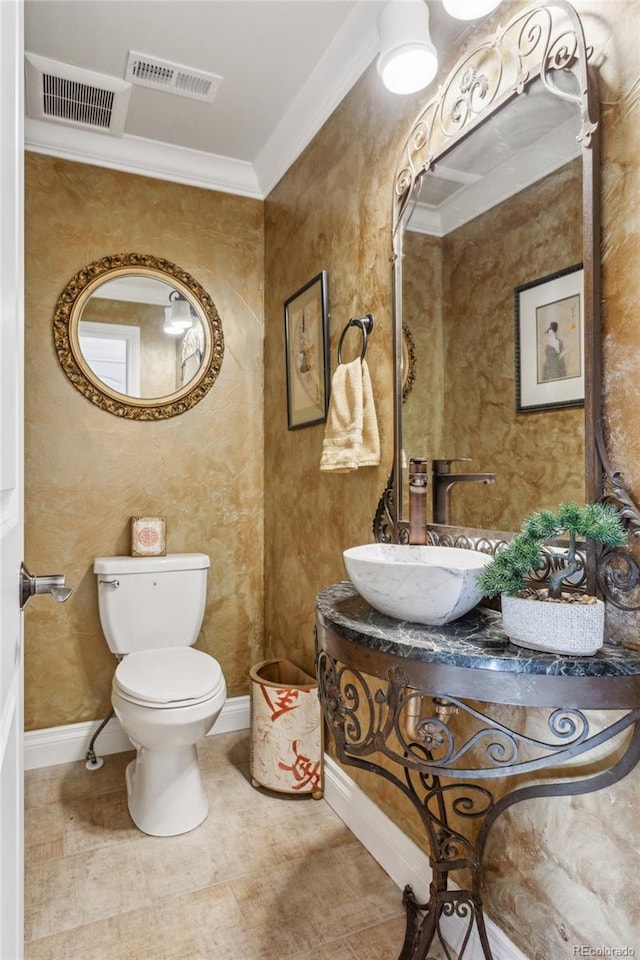 half bath featuring crown molding, visible vents, a sink, and toilet