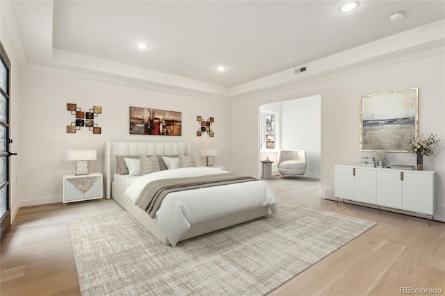 bedroom featuring recessed lighting, a raised ceiling, visible vents, and light wood finished floors