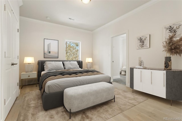 bedroom with light wood finished floors, visible vents, ornamental molding, and ensuite bathroom