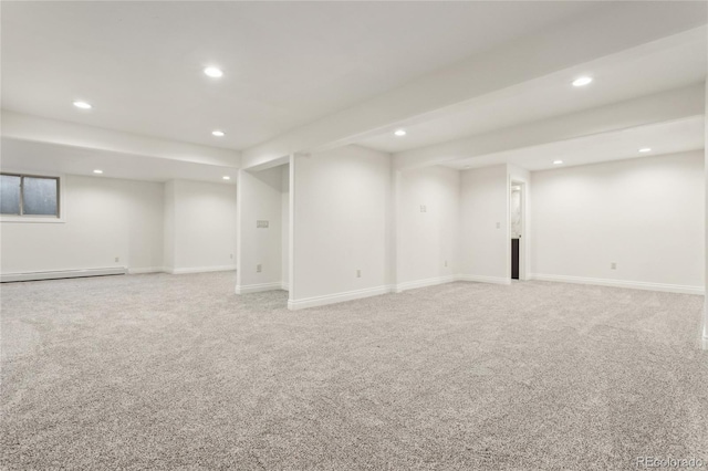 finished below grade area with a baseboard heating unit, baseboards, light colored carpet, and recessed lighting