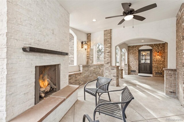 interior space featuring a ceiling fan and an outdoor stone fireplace