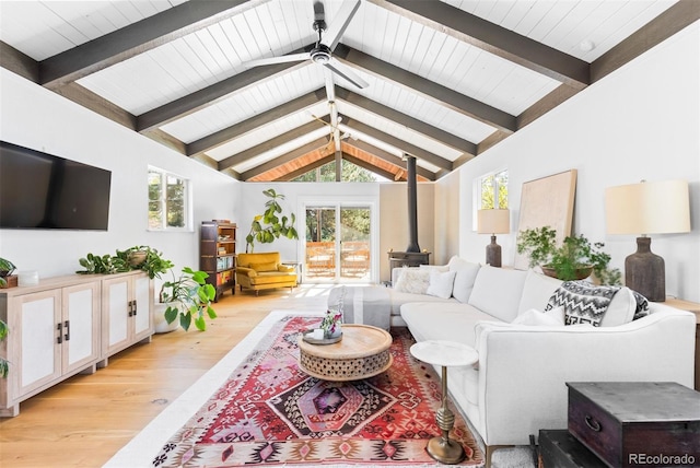 living room with a wood stove, light wood-type flooring, plenty of natural light, a ceiling fan, and wood ceiling