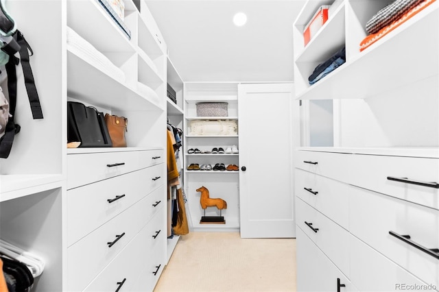 walk in closet featuring light colored carpet