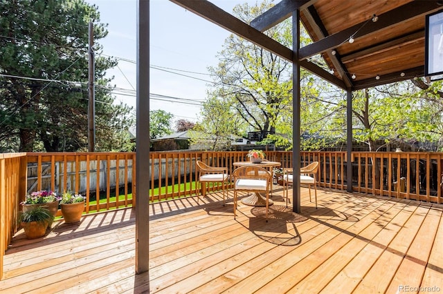 wooden terrace with a fenced backyard