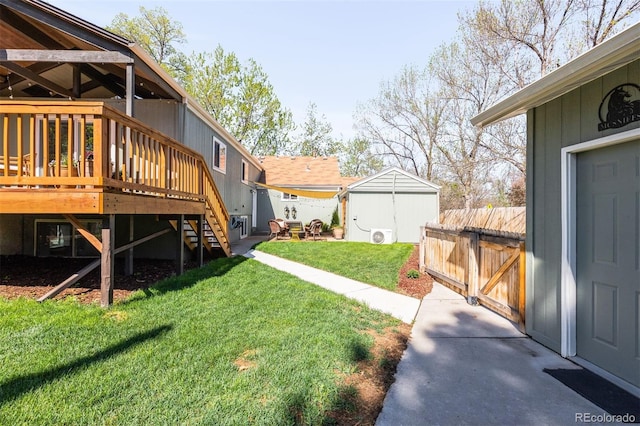 view of green lawn featuring a deck, an outdoor structure, stairs, and a storage unit