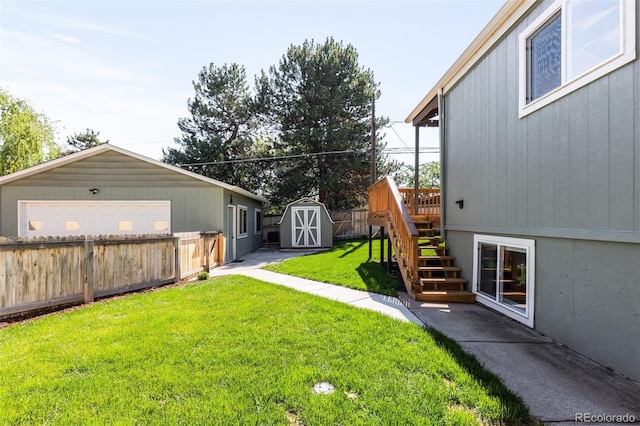 view of yard with an outbuilding, a detached garage, and a storage shed
