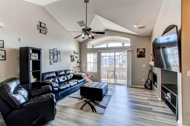 living area featuring lofted ceiling, ceiling fan, wood finished floors, and visible vents