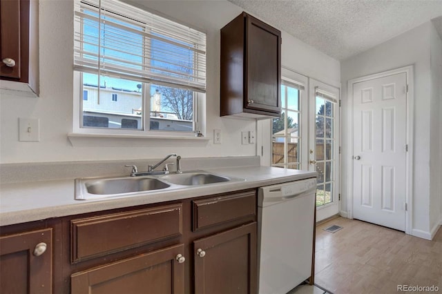 kitchen with visible vents, dishwasher, a sink, light countertops, and a textured ceiling