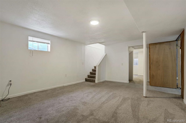 below grade area with stairs, baseboards, and carpet floors