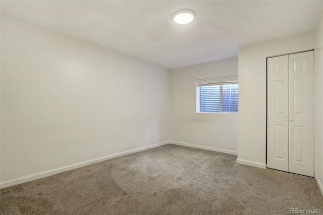 unfurnished bedroom with a closet, carpet, and baseboards