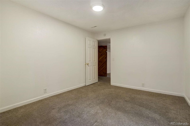 empty room featuring carpet and baseboards