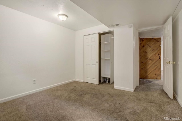 unfurnished bedroom with a closet, visible vents, baseboards, and carpet