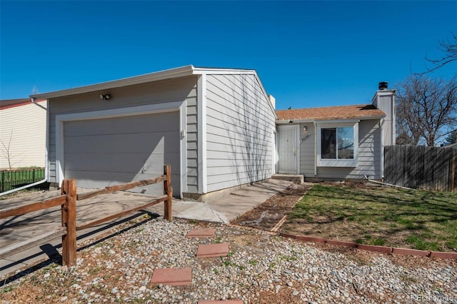 view of front of property featuring entry steps, a chimney, driveway, and fence