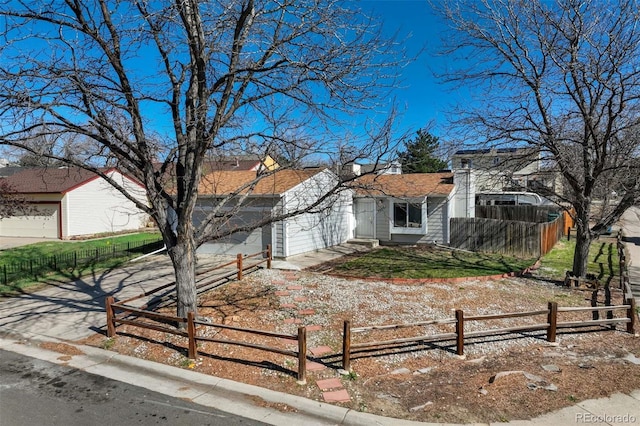 view of front of house featuring a fenced front yard, a garage, and concrete driveway