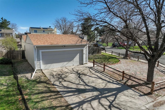 garage with fence and driveway