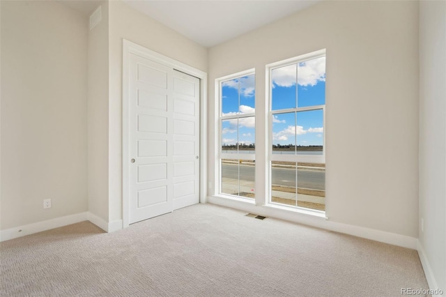 unfurnished bedroom with visible vents, baseboards, and carpet floors