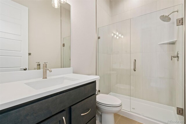 full bathroom with vanity, toilet, a shower stall, and tile patterned flooring