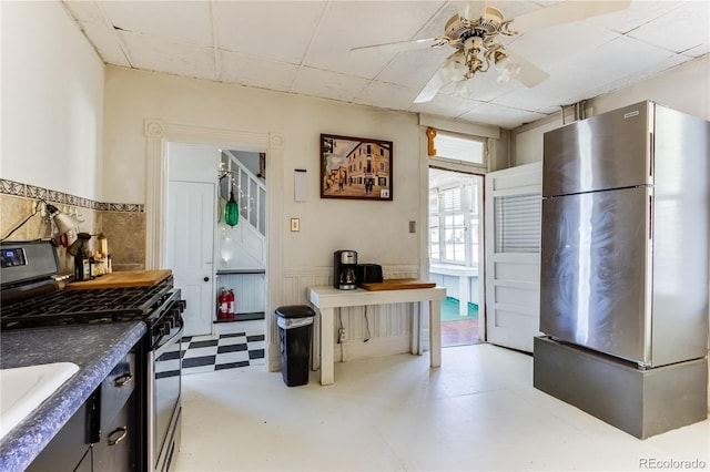 1601 San Pedro Ave, Trinidad, CO 81082 - kitchen featuring a sink, stainless steel appliances, light floors, wainscoting, and ceiling fan