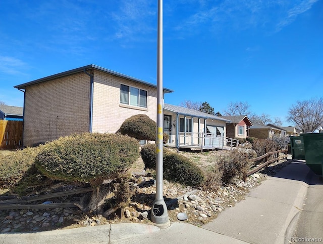 exterior space featuring brick siding and fence