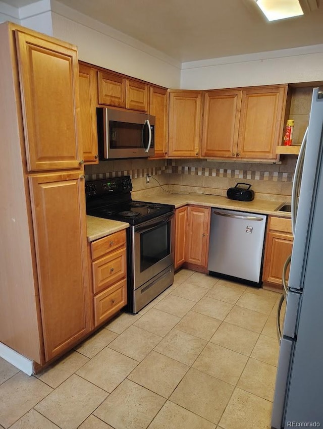 kitchen with light countertops, light tile patterned floors, tasteful backsplash, and stainless steel appliances