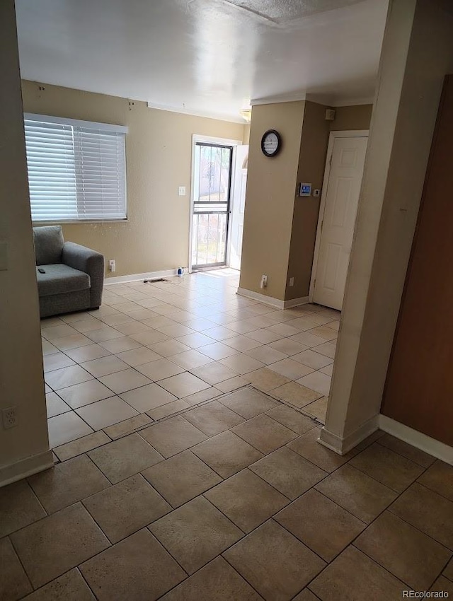 unfurnished living room with light tile patterned floors and baseboards