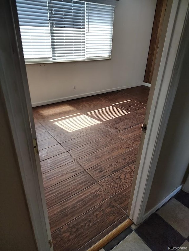 spare room featuring baseboards and a healthy amount of sunlight