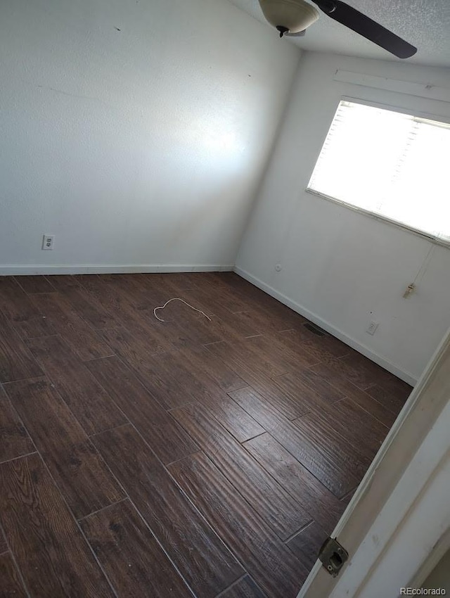 empty room featuring hardwood / wood-style flooring, a ceiling fan, and baseboards