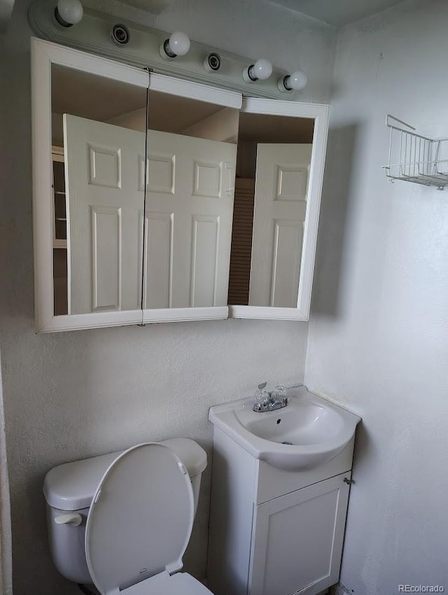 bathroom featuring toilet and vanity