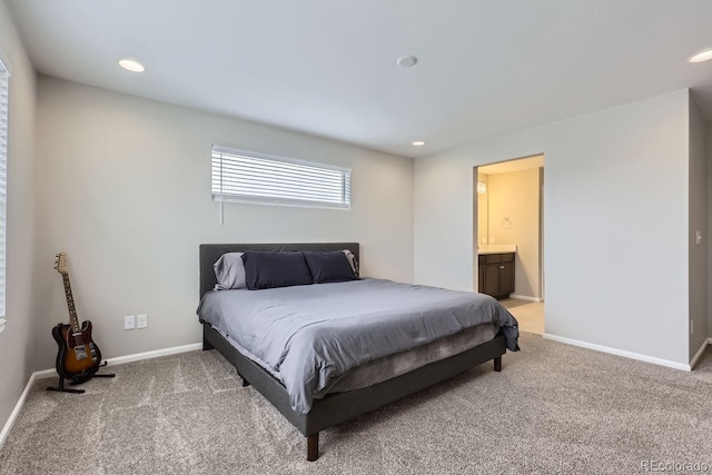 bedroom featuring light colored carpet, baseboards, ensuite bathroom, and recessed lighting