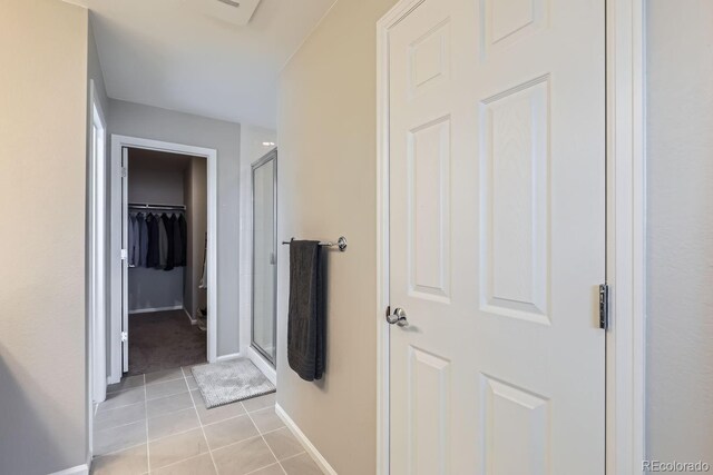 hallway featuring light tile patterned flooring and baseboards