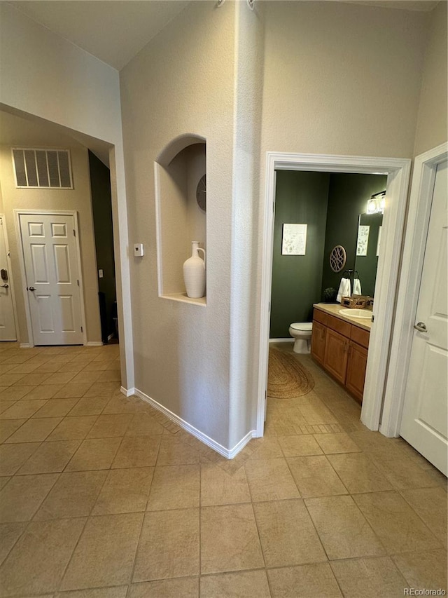 hall with light tile patterned floors and sink