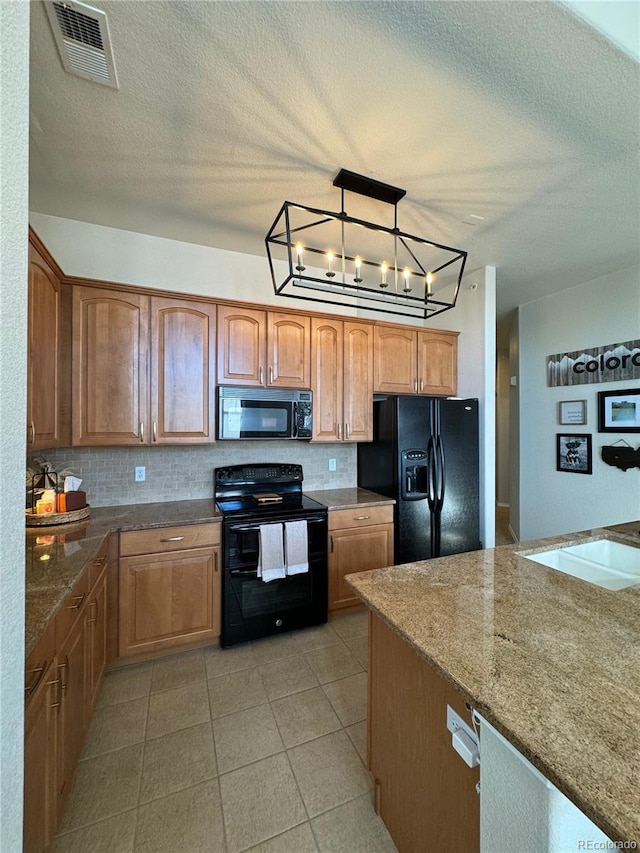 kitchen with pendant lighting, black appliances, a textured ceiling, tasteful backsplash, and a chandelier