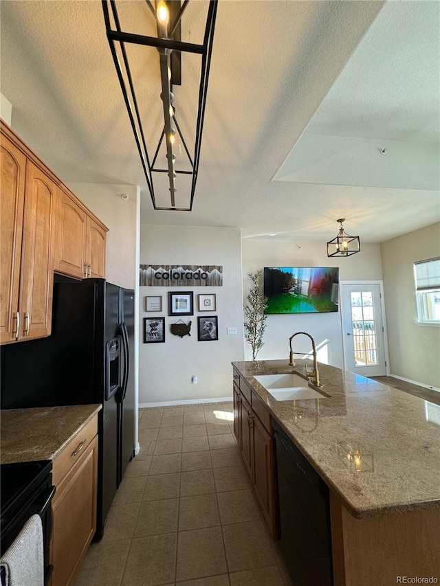 kitchen featuring a textured ceiling, a kitchen island with sink, sink, black appliances, and an inviting chandelier