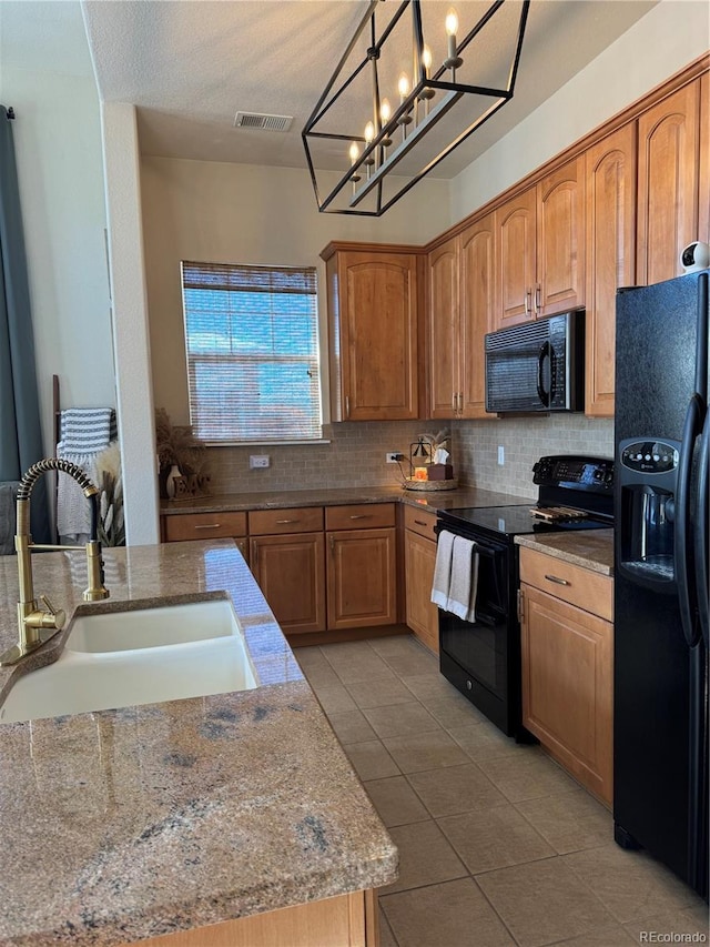 kitchen featuring sink, decorative light fixtures, decorative backsplash, light tile patterned floors, and black appliances